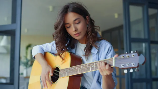 Hon övar musik på gitarr. Kvinnlig gitarrist spelar ackord på gitarr — Stockfoto