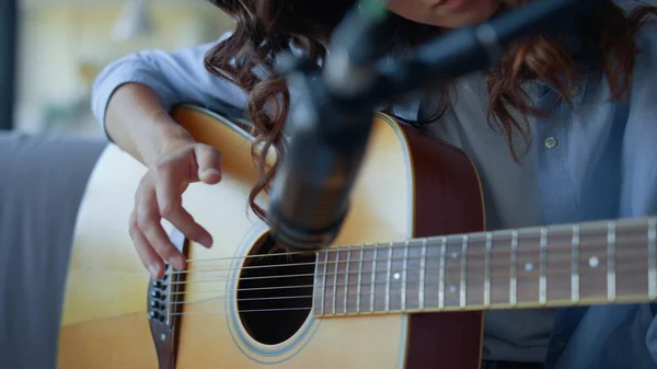 Flicka fingrar strummande strängar av gitarr. Kvinnan spelar in gitarrljud — Stockfoto
