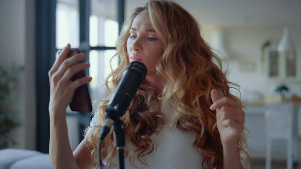 Attraktiv kvinna som sjunger i mikrofon. Kvinnlig sångare rör sig i musikens rytm — Stockfoto