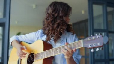 Gitarla müzik yapan bir kız. Gitar çalan düşünceli bir gitarist.