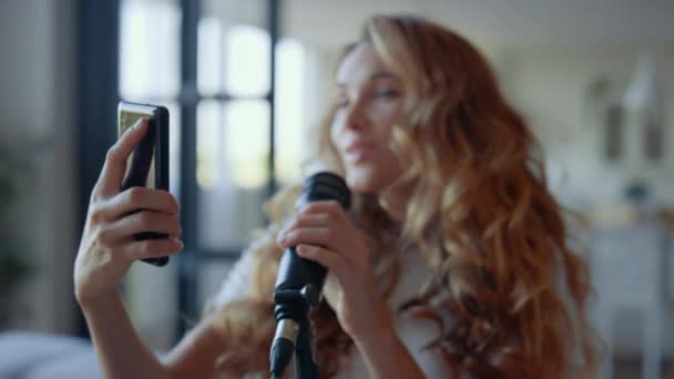 Uma mulher a cantar no microfone. Vocalista procurando texto de música no smartphone — Vídeo de Stock