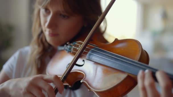 Chica tocando el violín en casa. Violinista tocando acordes en instrumento musical — Vídeos de Stock