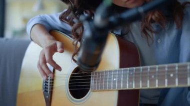 Kız parmakları gitar tıngırdatıyor. Gitar sesi kaydeden kadın