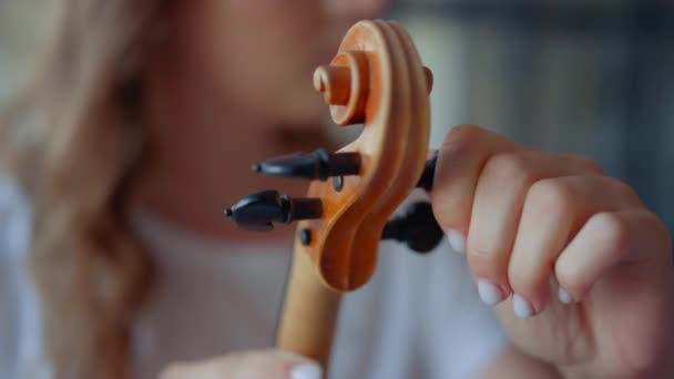Adolescente menina mãos afinando violino. Jovem mulher verificando pinos de violino — Vídeo de Stock