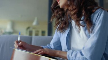 Gitarlı kız evde müzik yazıyor. Gitarist not defterine not alıyor.