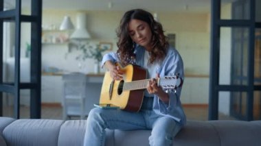 Evde gitar çalan bir kız. Müzisyen enstrüman çalmayı öğreniyor