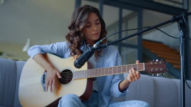 Девушка играет на гитаре в домашней студии. Музыкант записывает звук гитары — стоковое видео