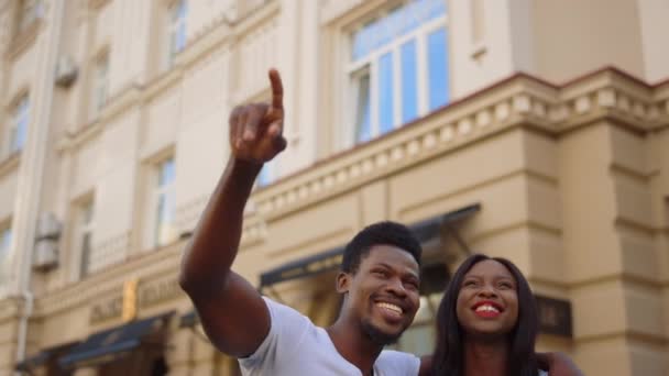 Африканская американка и парень проводят время на свежем воздухе. Пара смеющихся в городе — стоковое видео