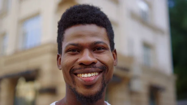 一个快乐的非洲男人在城市里摆姿势。在外面笑着看着相机的家伙 — 图库照片