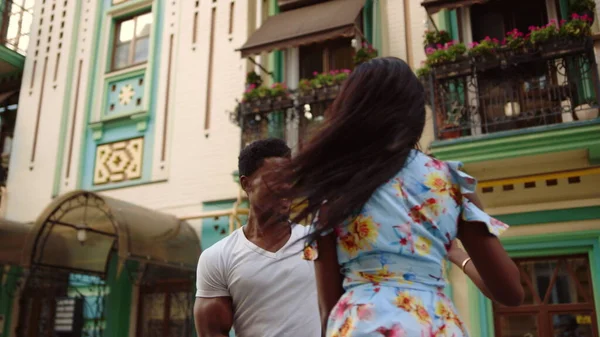 Young afro man and woman dancing bachata on street. Afro couple performing dance