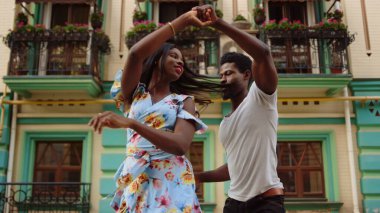 Şehirde Latin dansında kıvrılan mutlu afro dansçılar. Sokakta dans eden çift