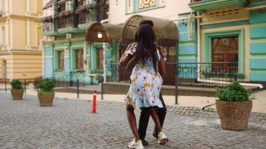 Gülümseyen Afrikalı dansçılar şehirde gösteri yapıyorlar. Erkek başroldeki kadın dansçı