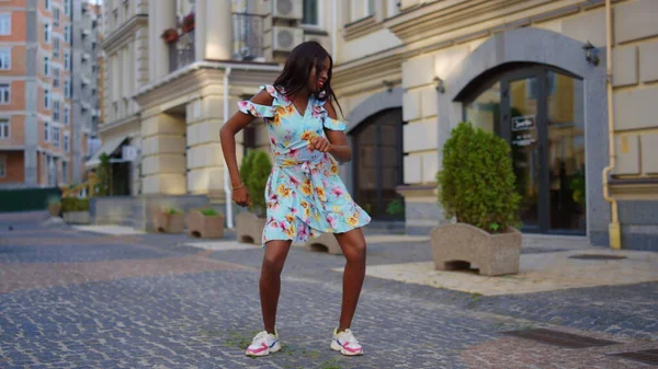 Linda senhora afro dançando dança latina na rua. Menina bachata dançando na cidade — Fotografia de Stock