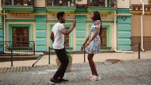 Cute afro couple performing latino dance in city. Man and woman dancing bachata