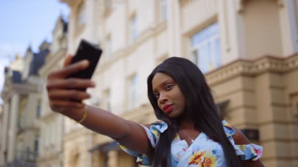 Affascinante afro ragazza in posa sulla fotocamera del telefono sulla strada. Signora in possesso di cellulare in città — Video Stock