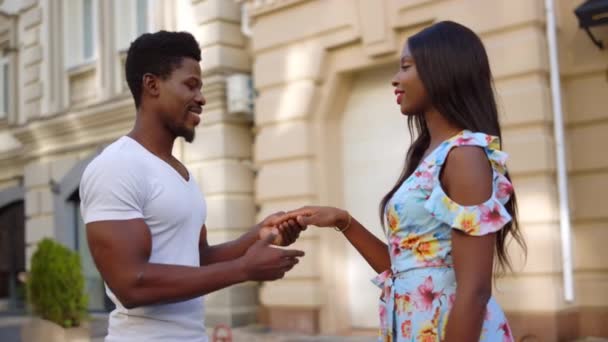 Афро-пара, встречающаяся на улице. Африканский мужчина целует женщину руку в городе — стоковое видео