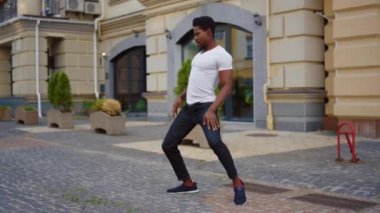 Açık havada Latin dansı yapan yakışıklı afro adam. Seksi afro adam dans ediyor.