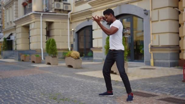 Un tipo enérgico bailando baile latino en la calle. Hombre haciendo elementos de baile en la ciudad — Vídeos de Stock