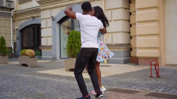 Elbűvölő afrikai férfi és nő táncolnak az utcán. Édes pár táncol a városban — Stock videók