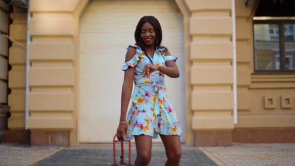 Chica afro sonriente bailando bachata en la ciudad. Mujer africana moviendo cuerpo en la calle — Vídeo de stock