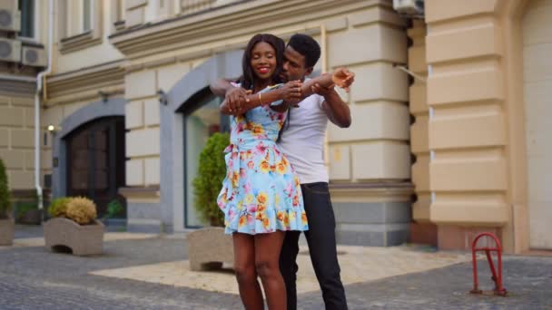 Çekici Afrikalı çift dışarıda dans ediyor. Kadın ve erkek sokakta hamle yapıyor. — Stok video