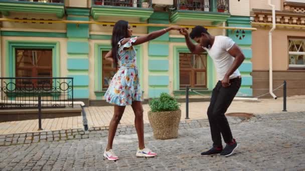 Африканская пара танцующих джайв в городе. Сексуальные афро-танцоры делают ноги на улице — стоковое видео