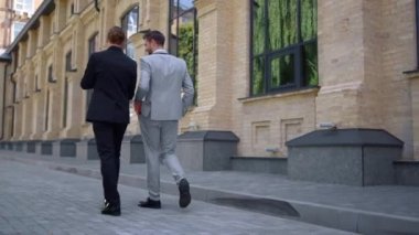 Arka plan iş adamları sokakta konuşuyor. Beyaz yakalı adamlar işe gidiyor..