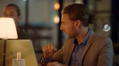 Adam bilgisayarda kadınlara bir şey gösteriyor. İnsanlar fikirleri tartışıyor.