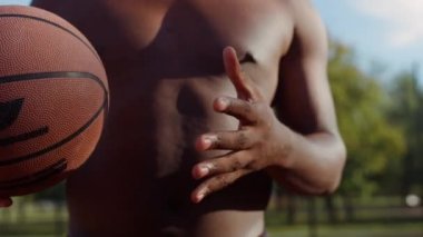 Bilinmeyen Afro-Amerikan sokak basketbolcusu dışarıda tek başına antrenman yapıyor. 