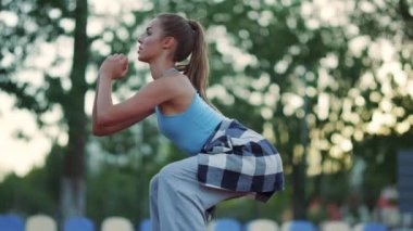 Aktif sporcu kadın dışarıda tek başına egzersiz yapıyor. Kız kardiyo egzersizi yapıyor. 