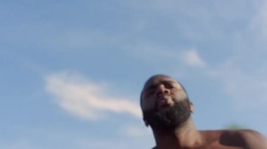 Güçlü afro sporcu sokak basketbolu antrenmanı yapıyor. Sportif adam dışarıda antrenman yapıyor. 