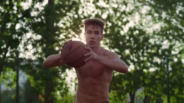 Jugador muscular enfocado practicando baloncesto callejero en el patio de recreo deportivo. — Vídeos de Stock