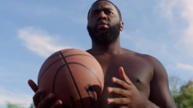 Sportif Afro-Amerikan sokak basketbolcusu dışarıda tek başına antrenman yapıyor..