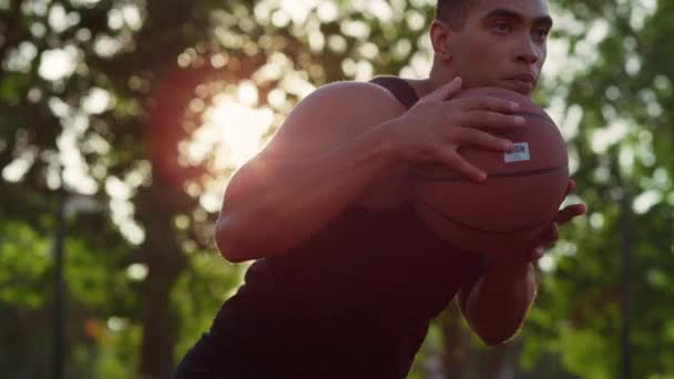 Крупным планом сфокусированный игрок в стритбол делает попытку забить гол на открытом воздухе. — стоковое видео