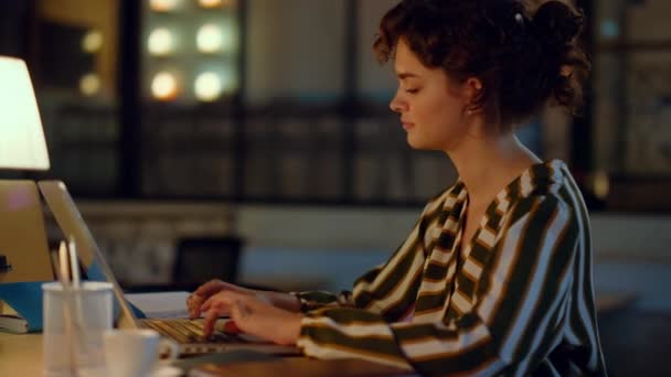 Krásná žena psaní na počítači ve spolupráci. Dívka pracující na notebooku uvnitř. — Stock video