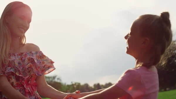 Alegre familia engañando en el parque de la ciudad. Madre e hija divirtiéndose al aire libre. — Foto de Stock