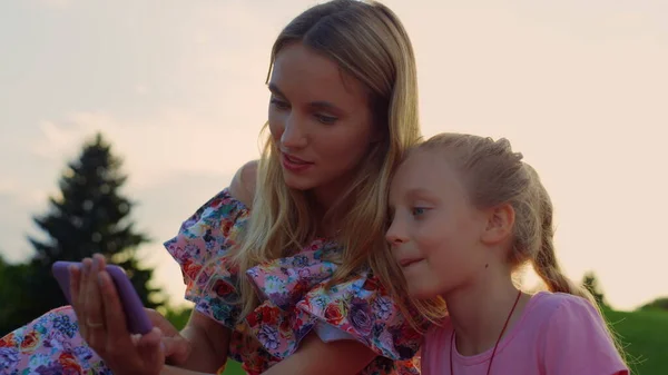 Família a tirar selfie no parque da cidade. Mulher e menina olhando para celular ao ar livre. — Fotografia de Stock