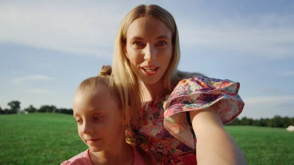 Mère et fille souriantes posant pour caméra de téléphone portable dans le parc de la ville. — Photo