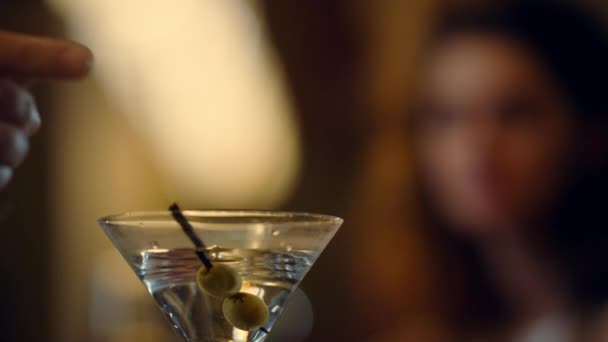 Nahaufnahme Hand Oliven in Glas legen. Modemodel trinkt Martini in Bar. — Stockvideo
