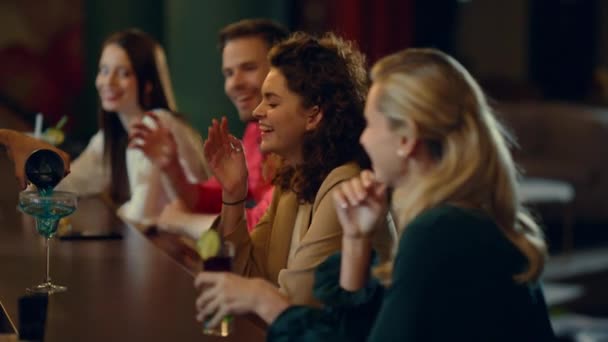 Amigos sorridentes a beber cocktails no bar. Pessoas batendo óculos no balcão. — Vídeo de Stock
