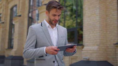 Tableti hareket halinde kullanmasına şaşırdım. İş adamı dışarıda mesaj aygıtını okuyor