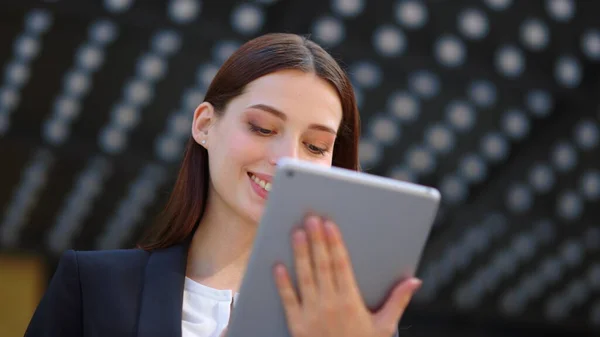Businesswoman face looking tablet screen. Woman using digital device outdoors.