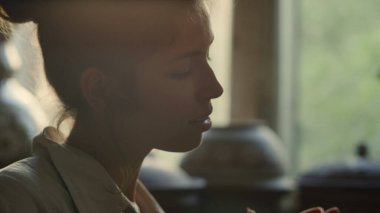 Atölyede çömlek inceleyen neşeli bir sanatçı. Çömlekte dönen kadın.