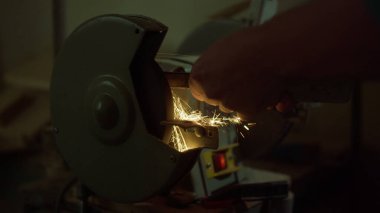 Kapalı alanda tanınmayan marangoz bileme aleti. Makineden kıvılcımlar saçar