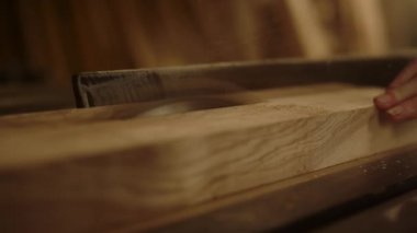 Tanımlanamayan adam içeride ürün için kalas hazırlıyor. Testere kullanan adam