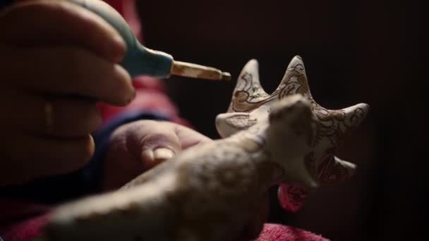 Closeup mulher mãos produto de decoração em cerâmica. Ceramista pintura brinquedo cervos — Vídeo de Stock