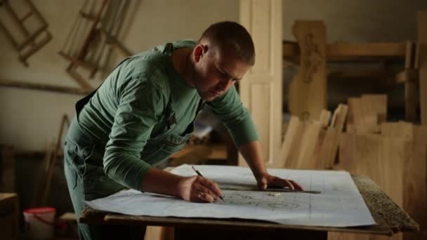 Homme concentré faisant des dessins pour les produits en bois à l'intérieur. Guy dessin ornement — Video