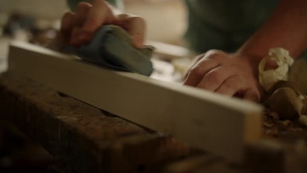 Handwerker bereiten Holz für Produkte in Innenräumen vor. Mann benutzt Schleifpapier im Atelier — Stockvideo