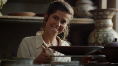 Çömlekçilikle oynayan heyecanlı bir sanatçı. Çömlek çeviren kadın 