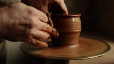 Çömlekçilik yapan kil sanatçısı. Atölyedeki ıslak çamurdan kavanoz oluşturan adam.